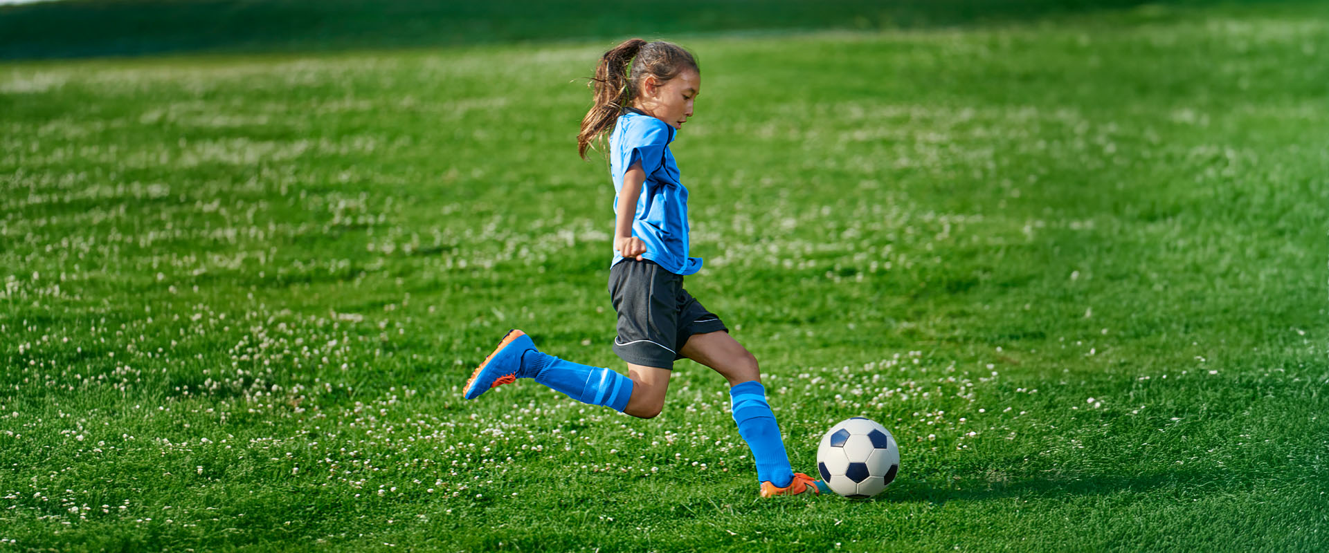 Girl kicking soccer ball in Queensland